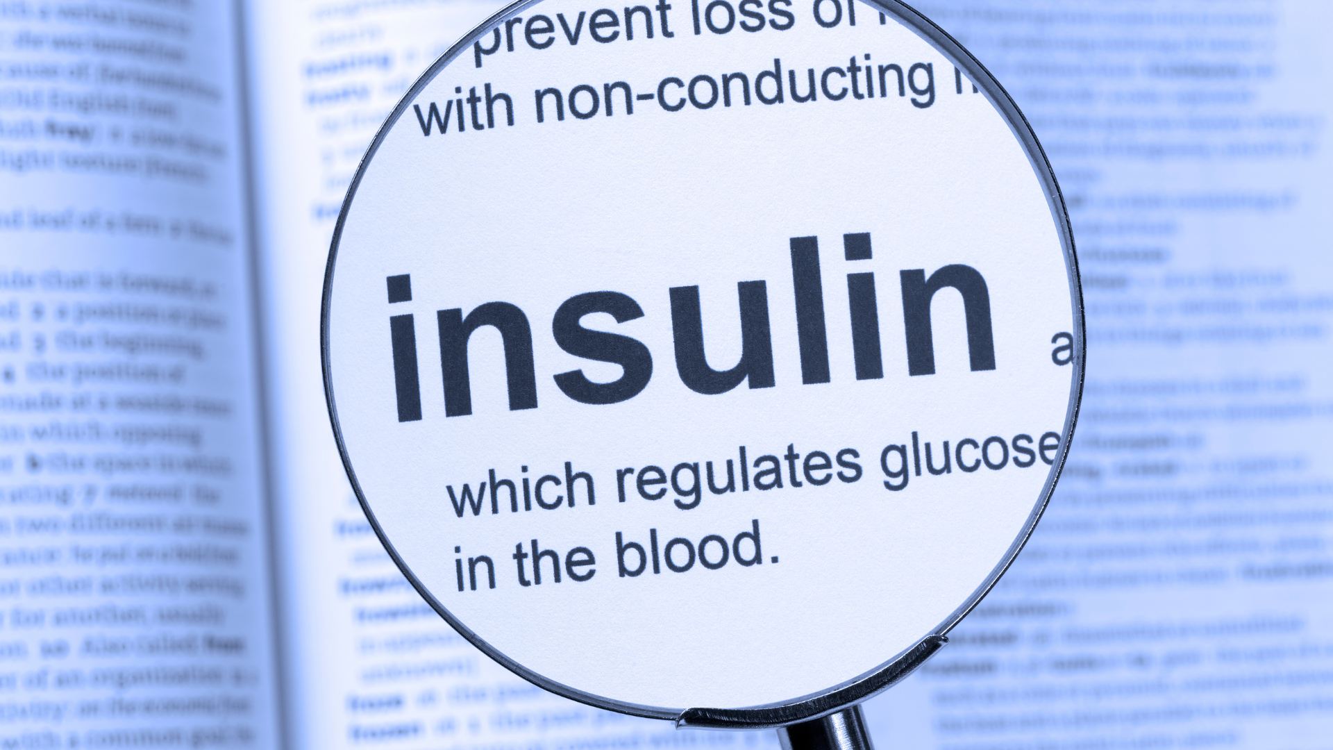 Magnifying glass centered over open book magnifying the word insulin