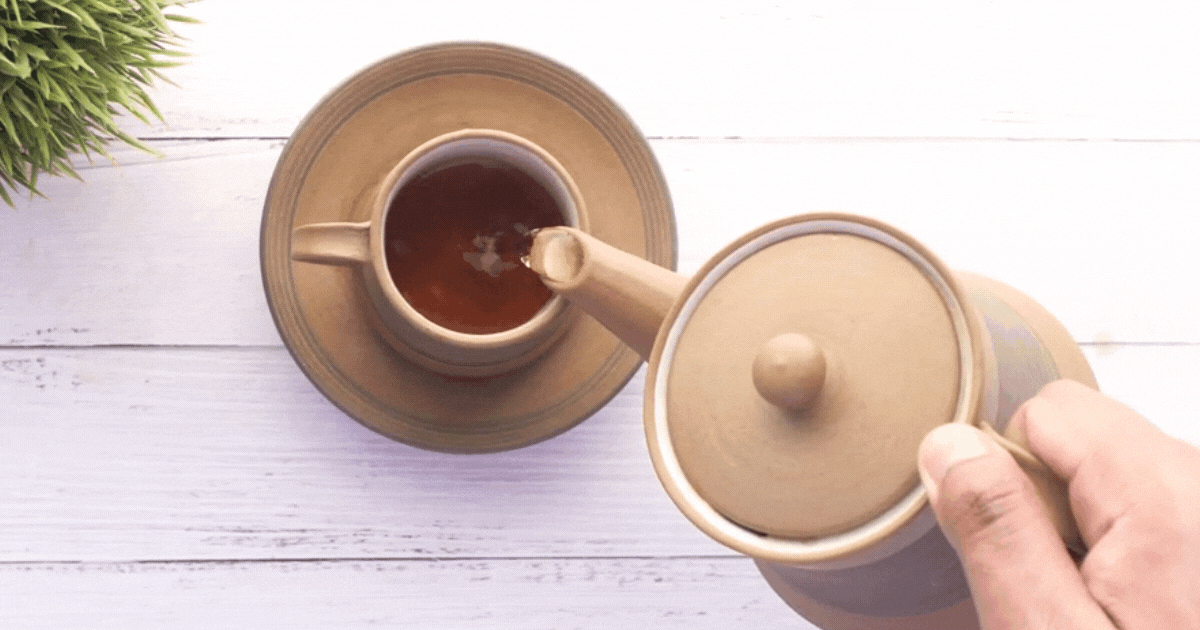 Tea from a post of loose tea pouring into a cup to avoid plastic exposure from tea bags
