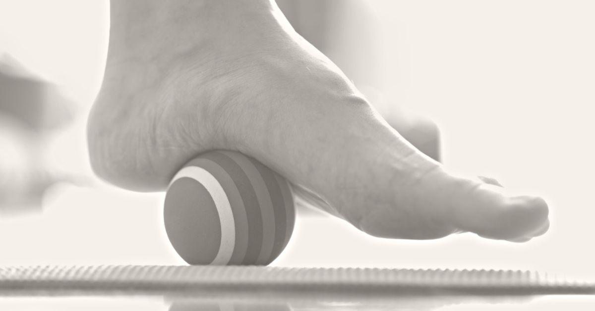 foot on ball rolling on floor beneath foot with text: 1 Minute Foot Massage Big Benefits A reflexology illsutration