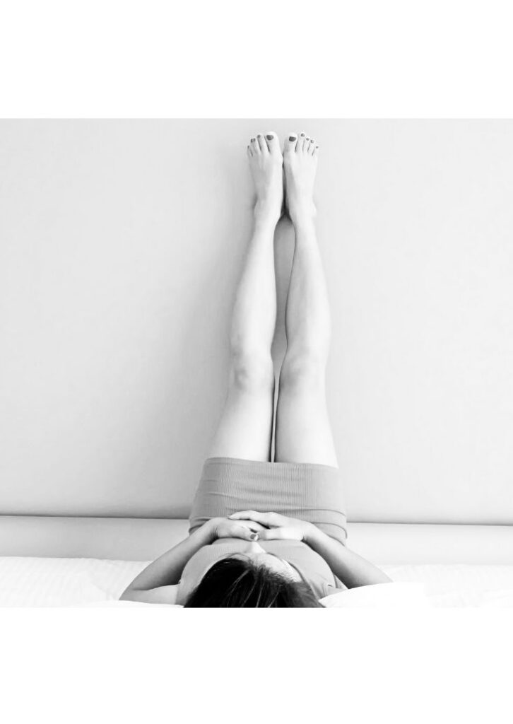 Woman on back with legs up the wall.