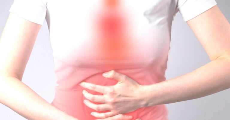 Woman with hands on stomach. Irritated digestive tract from indigestion