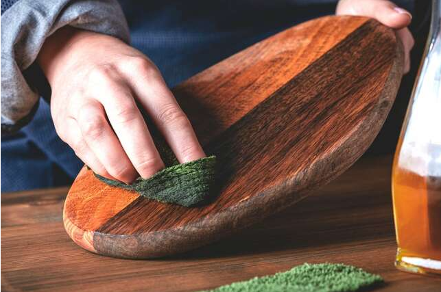person Oiling a cutting board. Article Best Non-toxic Cutting Boards.