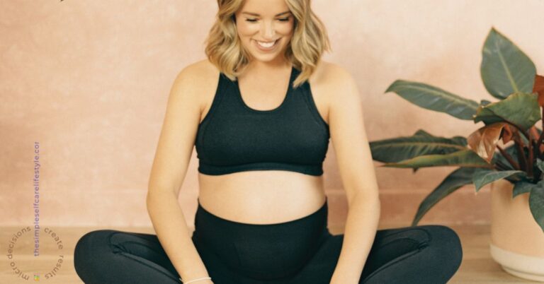 Pregnant woman in workout clothing sitting on the floor