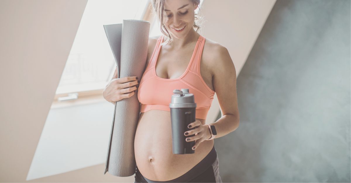 Pregnant woman holding exercise mat ready to do a pregnancy workout